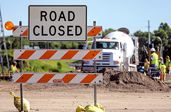 Road closed sign in front of an active construction site