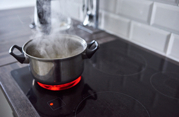 Hot cooking pot on heated stove top