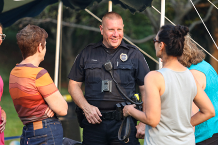 Residents and a police officer at a Night to Unite block party