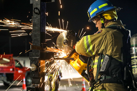 A Plymouth firefighter training with extrication tools