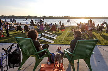 Group of people enjoying the sun, music and games at East Medicine Lake Park.