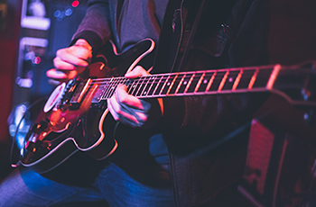 Photo of a person playing the electric guitar