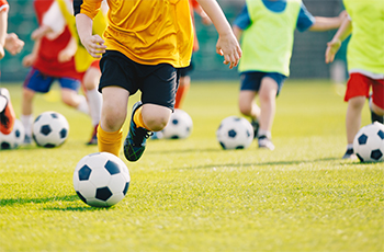 Photo of children playing soccer on a field