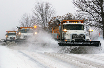 Image of three snowplows clearing snow in Plymouth