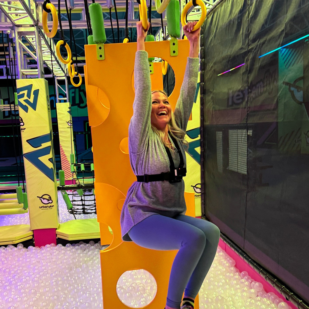 Women hanging from rings at Urban Air Adventure Park