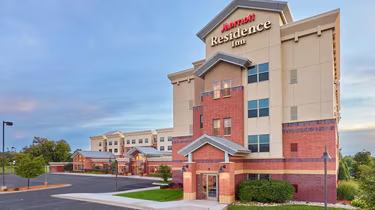 Photo of the exterior of the Residence Inn Hotel, which is tan and red.