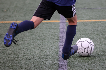 photo of person kicking a soccer ball