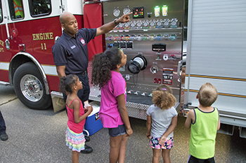 Plymouth firefighter teaching about fire trucks