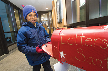 Child dropping off letter for Santa Claus at Plymouth City Hall