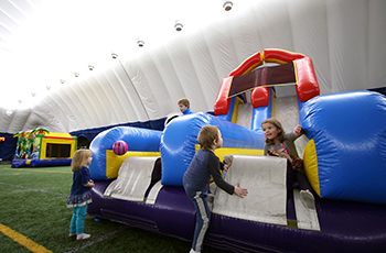 Children playing on inflatables during open play at the Plymouth Creek Center Fieldhouse dome