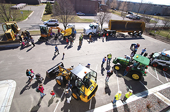 Residents exploring vehicles and equipment at the touch-a-truck portion of the City Sampler event at the Plymouth Maintenance Facility