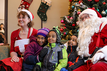 Kids sitting with Mr. and Mrs. Claus