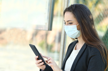 Woman on a smartphone wearing a mask