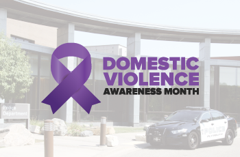 Image of Plymouth Police car and domestic violence awareness month ribbon