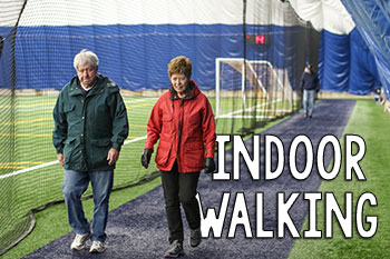 Image of two people walking inside of a fieldhouse