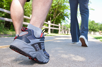 Photo of people's shoes as they walk along an outdoor trail