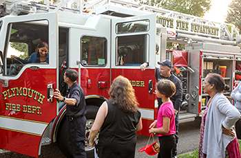 Plymouth firefighters giving a fire truck tour to residents during Night to Unite